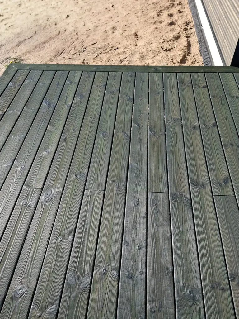 Charred spruce decking boards, Medeksa Moss color; a close-up view reveals the natural wood grain and a dark green hue